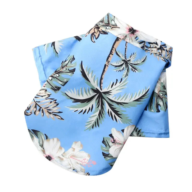 Tropical-themed fabric with palm leaves and flowers on a blue background