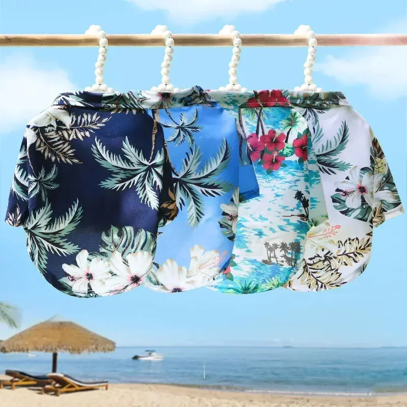 Three floral shirts hanging on a clothesline with a beach scene in the background.