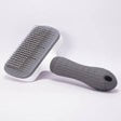 Gray pet grooming brush with a black handle on a white background