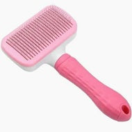 Pink pet grooming brush on a white background
